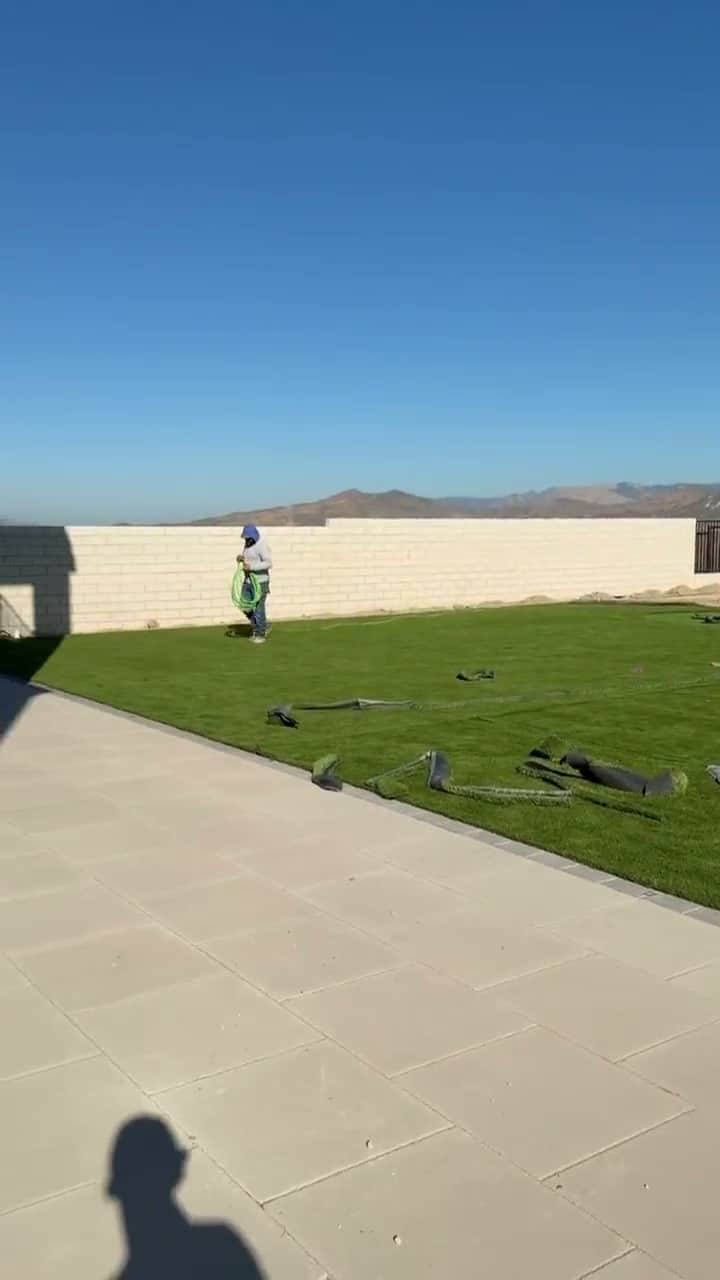 Five Stars Builders crew installing artificial turf in a new-construction backyard